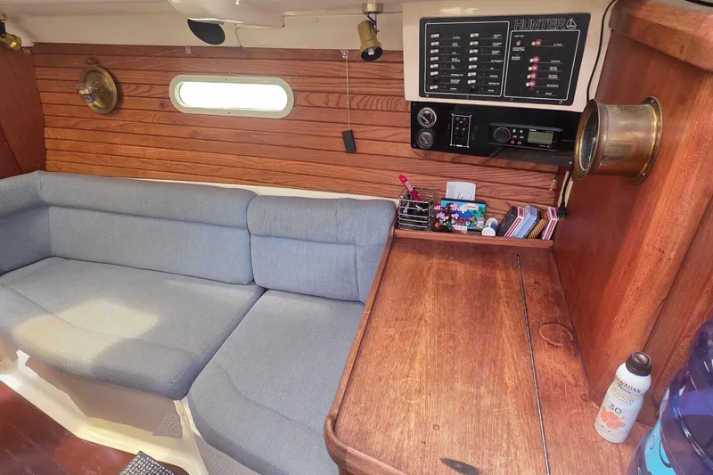 Slide: The Image of Interior of a 1995 Hunter 336 sailboat with wooden paneling and a cozy seating area. - 5