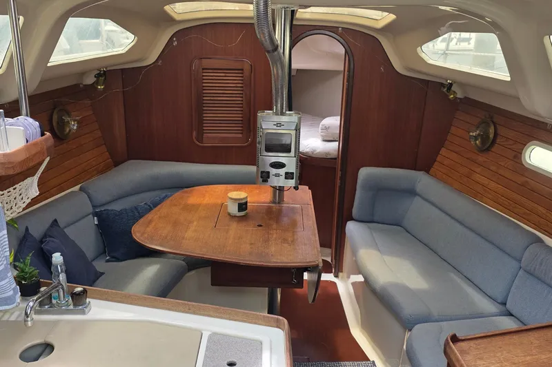 Slide: The Image of Interior of a 1995 Hunter 336 sailboat with cozy seating and wooden accents. - 6