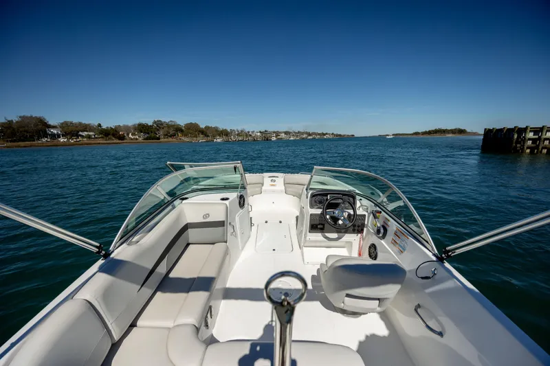 Slide: The Image of 2023 Hurricane SunDeck 187 OB boat on calm water, featuring spacious seating and modern controls. - 10