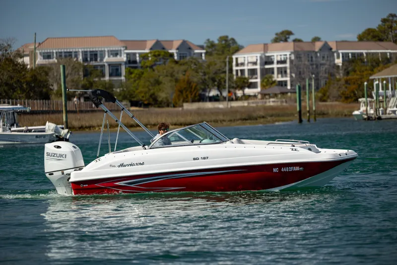 Slide: The Image of 2023 Hurricane SunDeck 187 OB boat cruising on a scenic waterway. - 6