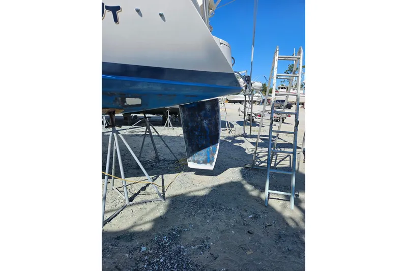 Slide: The Image of Hunter Vision 36 sailboat from 1993 on dry dock, with visible rudder and ladder. - 7