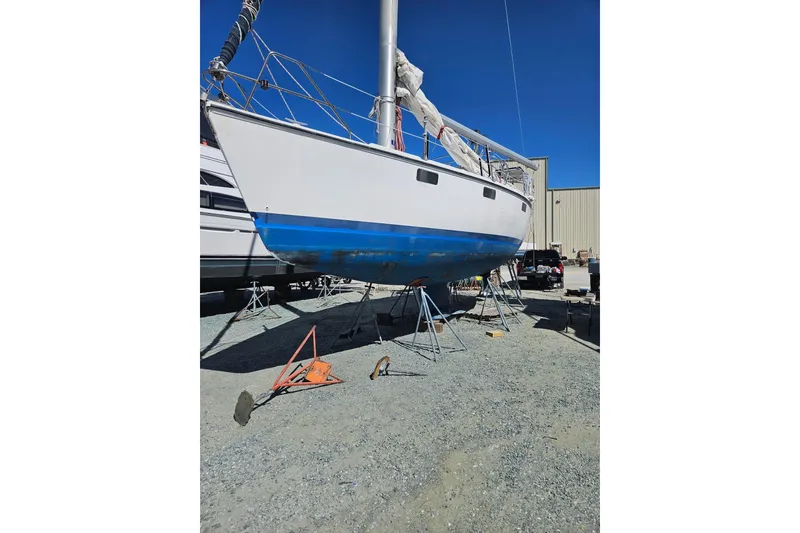 Slide: The Image of Hunter Vision 36 sailboat from 1993 on stands, undergoing maintenance in a boatyard. - 9