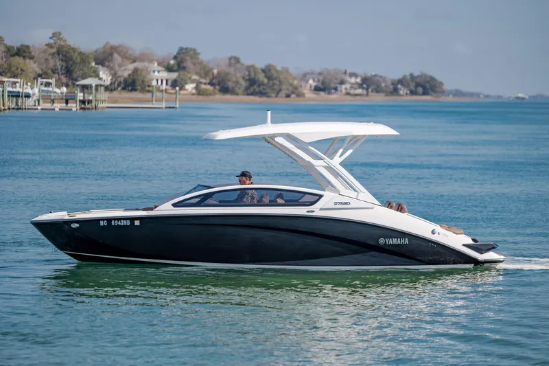 The Image of 2024 Yamaha Boats 275SD cruising on a serene lake with scenic background. - 1