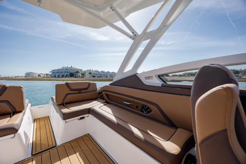 Slide: The Image of 2024 Yamaha Boats 275SD interior with luxurious seating and scenic waterfront view. - 17