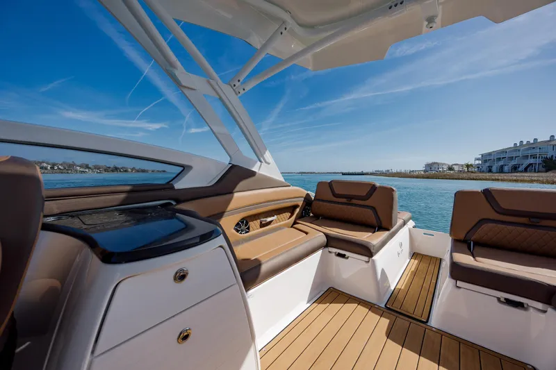 Slide: The Image of 2024 Yamaha Boats 275SD interior with luxurious seating and scenic waterfront view. - 18