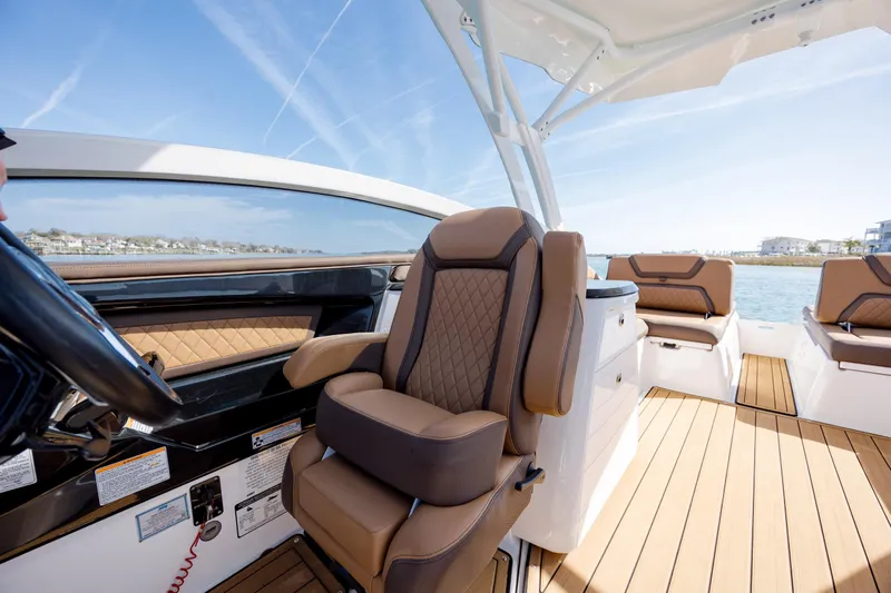 Slide: The Image of 2024 Yamaha Boats 275SD interior with luxurious seating and modern design on open water. - 19