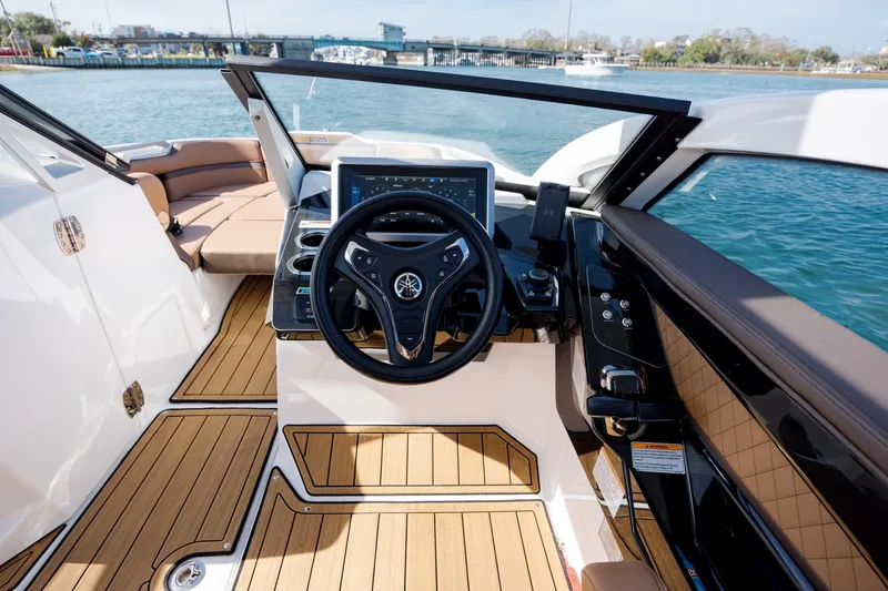 Slide: The Image of 2024 Yamaha Boats 275SD cockpit with modern steering and controls, overlooking serene waters. - 25