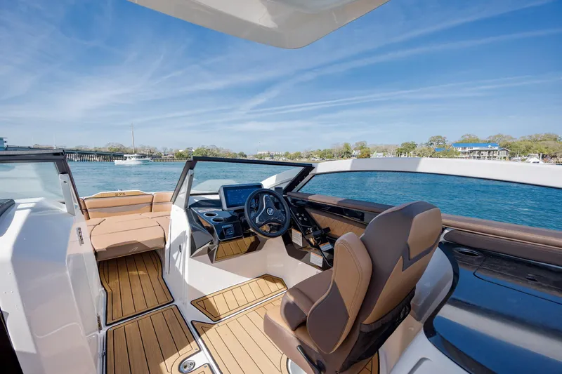 Slide: The Image of 2024 Yamaha Boats 275SD interior with sleek design, luxurious seating, and advanced dashboard on open water. - 26