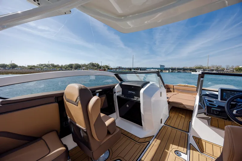 Slide: The Image of 2024 Yamaha Boats 275SD interior with luxurious seating and modern dashboard on a sunny day. - 27