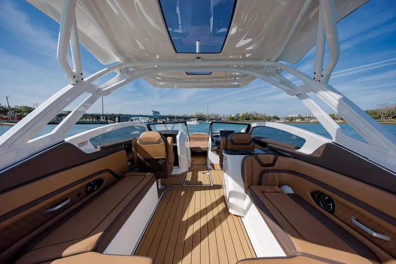 Slide: The Image of 2024 Yamaha Boats 275SD interior with luxurious seating and sleek design on open water. - 28