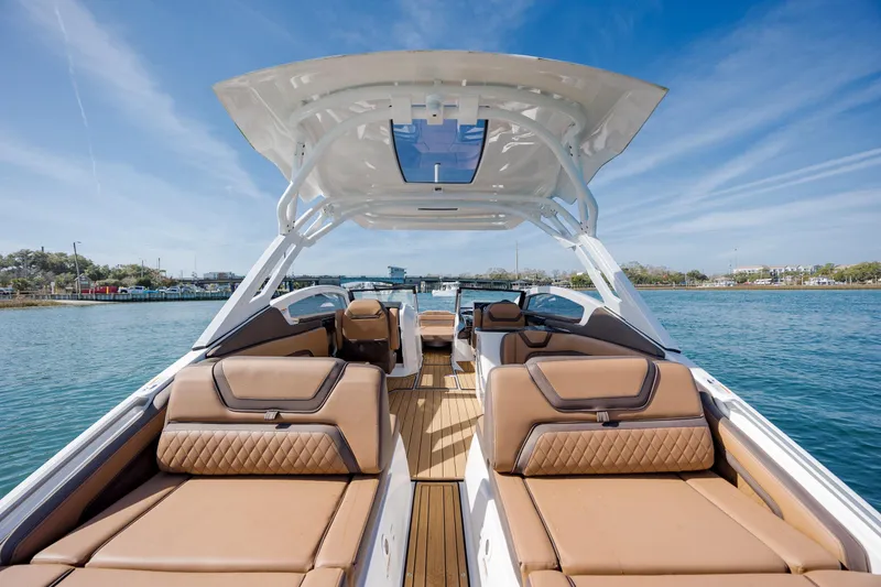 Slide: The Image of 2024 Yamaha Boats 275SD luxury interior with tan seating on a sunny day. - 29