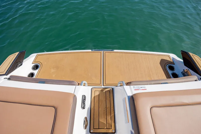 Slide: The Image of 2024 Yamaha Boats 275SD swim platform with teak finish on calm water. - 31