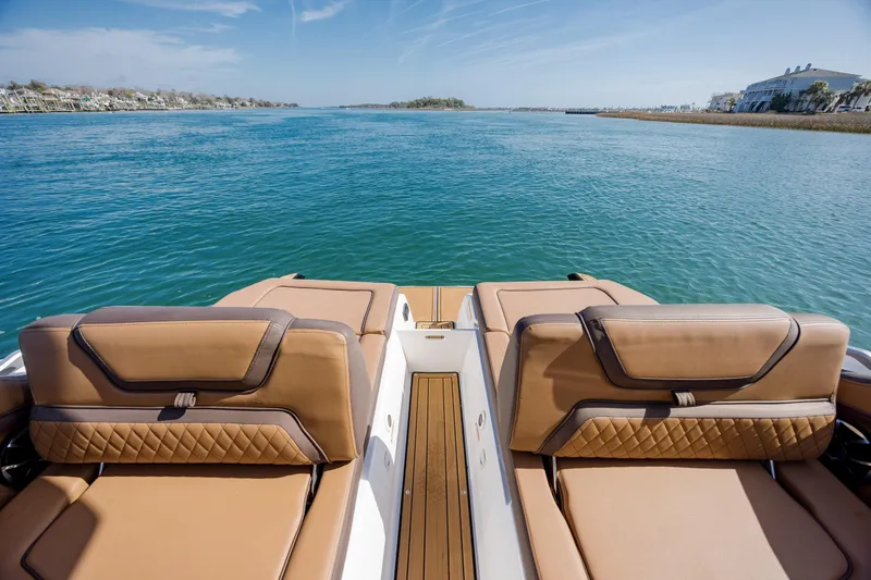 Slide: The Image of 2024 Yamaha Boats 275SD with luxurious seating, overlooking serene blue waters. - 32