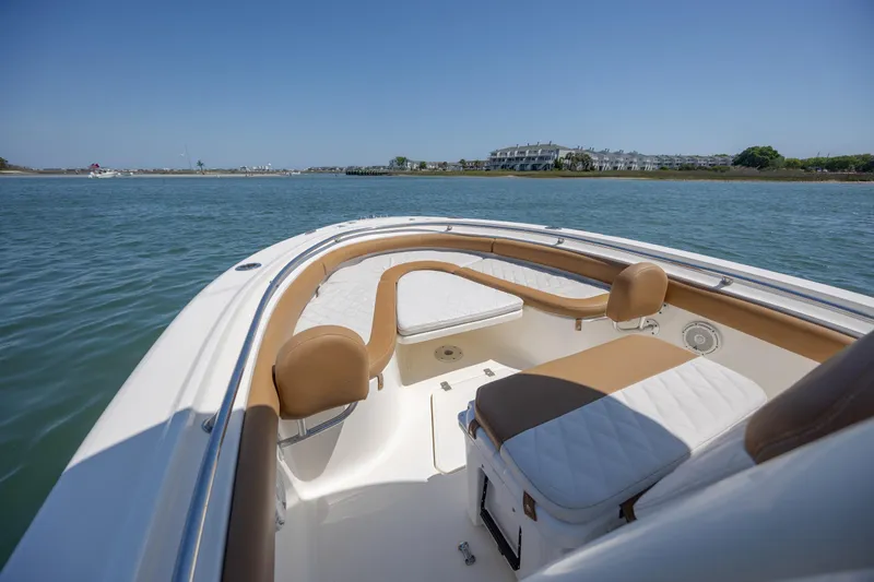 Slide: The Image of 2019 Pioneer 222 Sportfish boat interior with cushioned seating on calm water. - 10