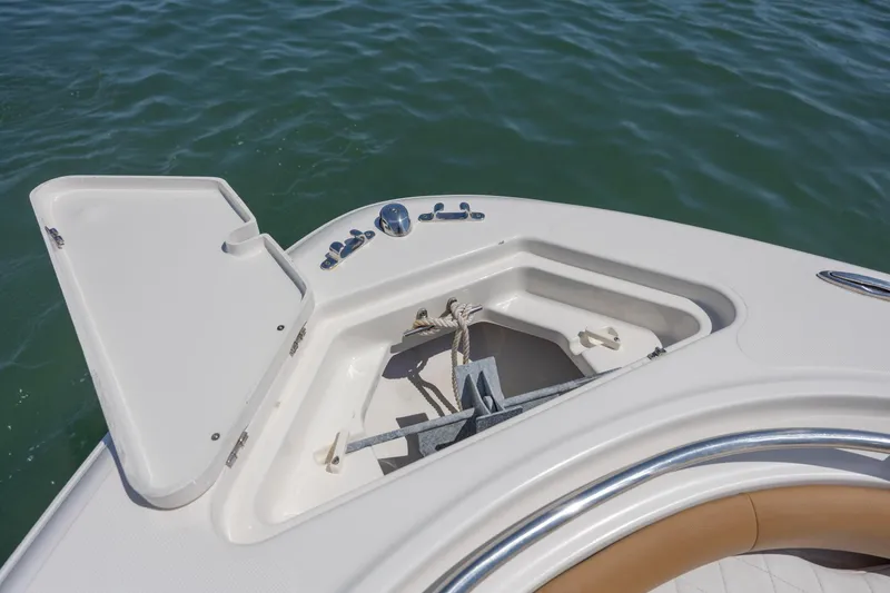 Slide: The Image of Open anchor compartment on 2019 Pioneer 222 Sportfish boat, floating on water. - 11