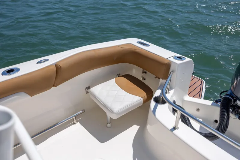 Slide: The Image of 2019 Pioneer 222 Sportfish boat interior with cushioned seating and ocean view. - 16