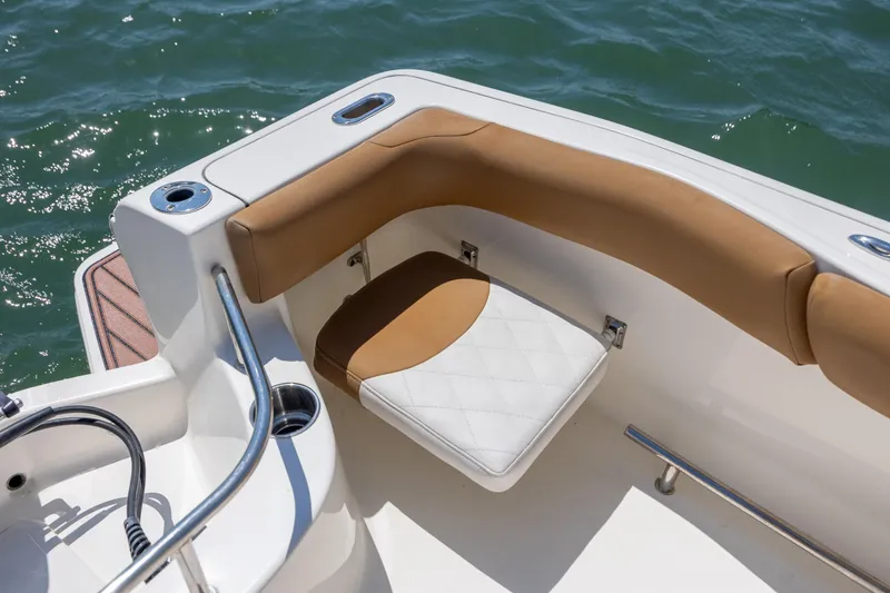 Slide: The Image of 2019 Pioneer 222 Sportfish boat interior with cushioned seating and stainless steel railing. - 17