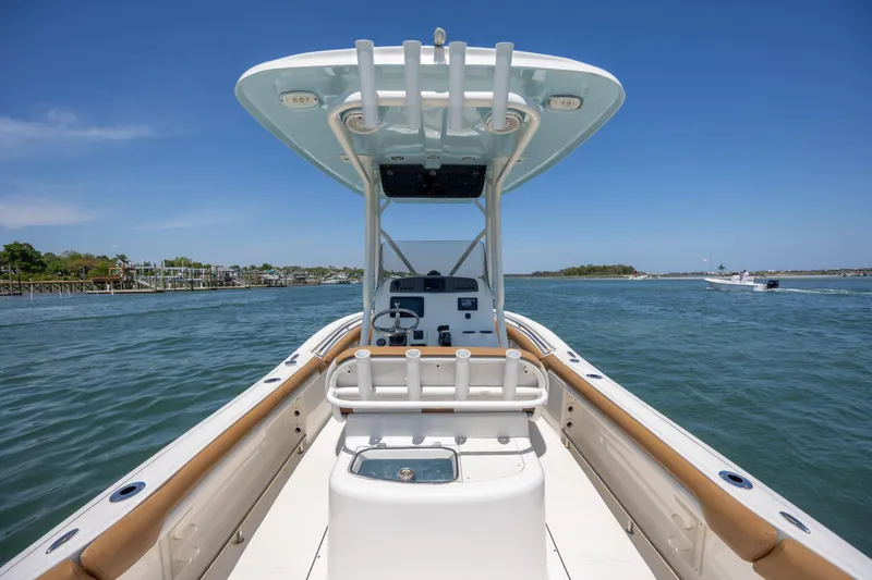 Slide: The Image of 2019 Pioneer 222 Sportfish boat on water, clear sky, coastal view. - 20