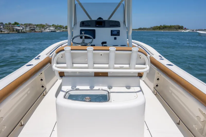 Slide: The Image of 2019 Pioneer 222 Sportfish boat interior with rod holders and steering console on open water. - 21