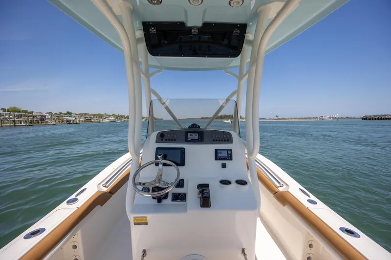 Slide: The Image of 2019 Pioneer 222 Sportfish boat dashboard with steering wheel on open water. - 22