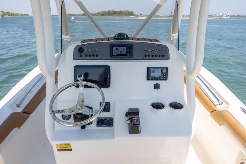 Slide: The Image of 2019 Pioneer 222 Sportfish boat dashboard with steering wheel and navigation controls. - 23