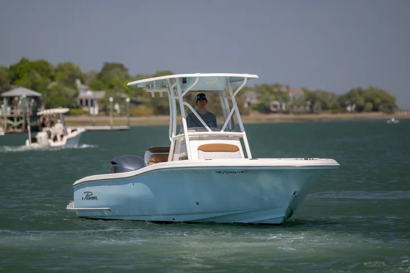 Slide: The Image of 2019 Pioneer 222 Sportfish boat cruising on a calm lake with scenic background. - 4