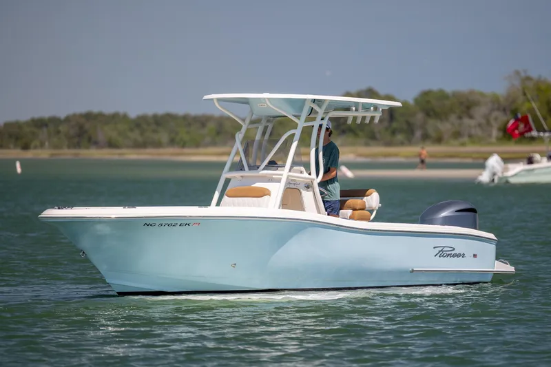 Slide: The Image of 2019 Pioneer 222 Sportfish boat cruising on a calm lake with scenic background. - 7