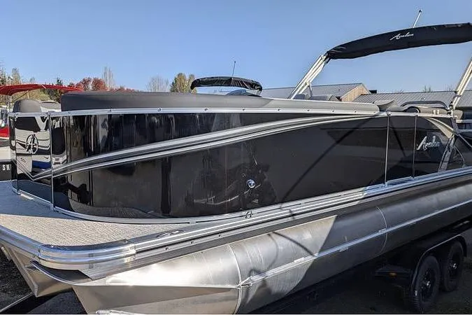 The Image of 2025 Avalon LSZ Cruise 24' pontoon boat with sleek black exterior design. - 0