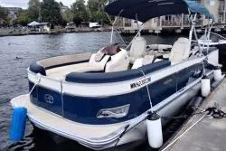 The Image of 2022 Avalon Catalina Quad Lounge 24' pontoon boat docked by the water. - 1