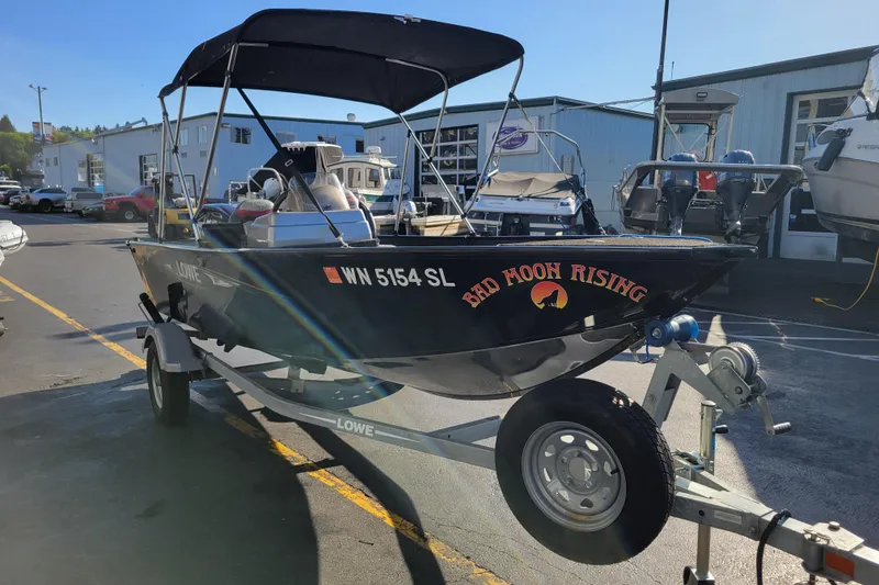 The Image of 2017 Lowe Fishing Machine 160T boat on trailer, labeled "Bad Moon Rising." - 0