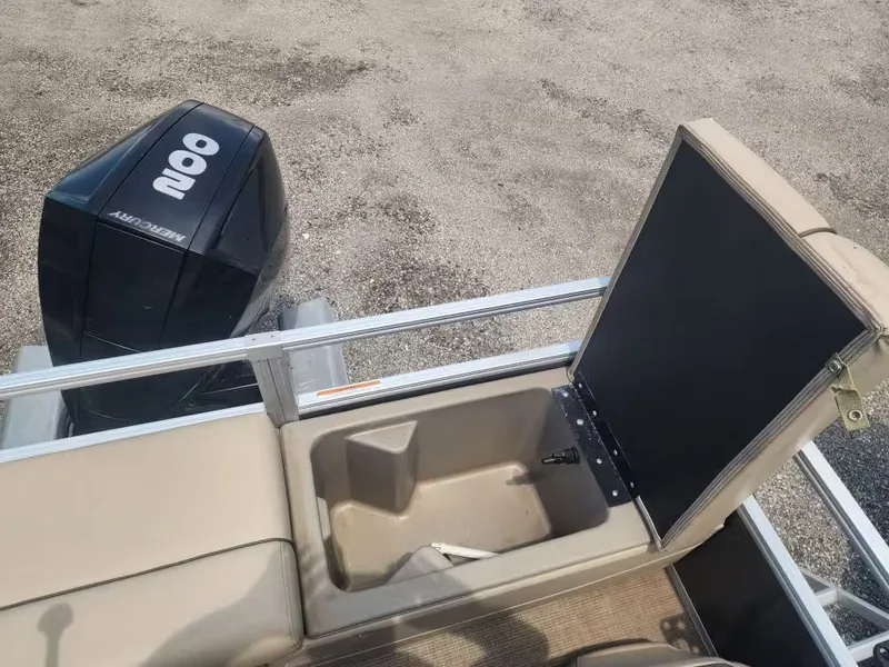 Slide: The Image of Sun Tracker 22 DLX 2022 with open storage compartment and Mercury engine. - 7