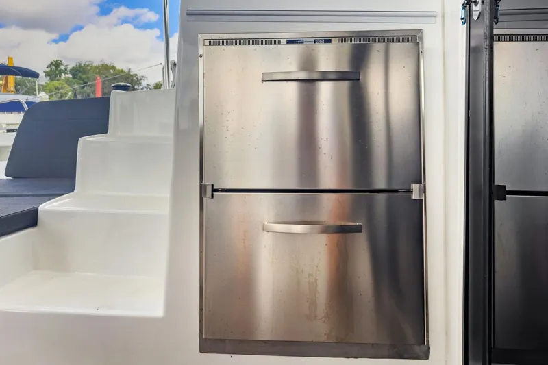 Slide: The Image of Stainless steel refrigerator on 2020 Lagoon 42 yacht, near white steps and outdoor seating. - 13