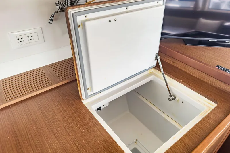 Slide: The Image of Open storage compartment on Lagoon 42 catamaran, 2020 model, with wooden finish. - 35