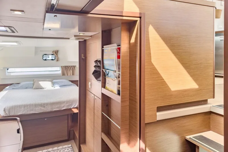 Slide: The Image of Interior of 2020 Lagoon 42 yacht featuring a cozy bedroom and modern wooden finishes. - 43