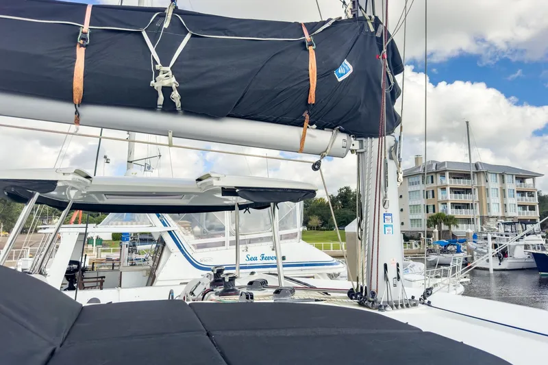 Slide: The Image of 2020 Lagoon 42 catamaran docked at marina with modern buildings in background. - 20