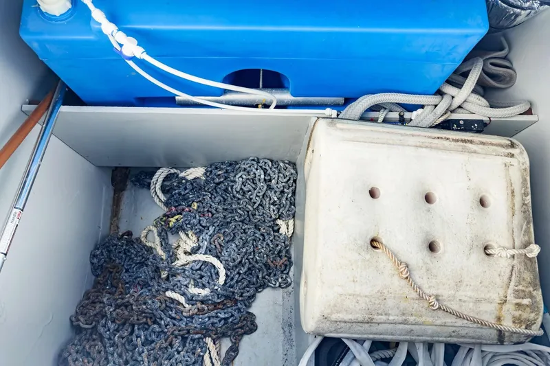 Slide: The Image of Storage compartment of 2020 Lagoon 42 with ropes, chains, and blue tank. - 82