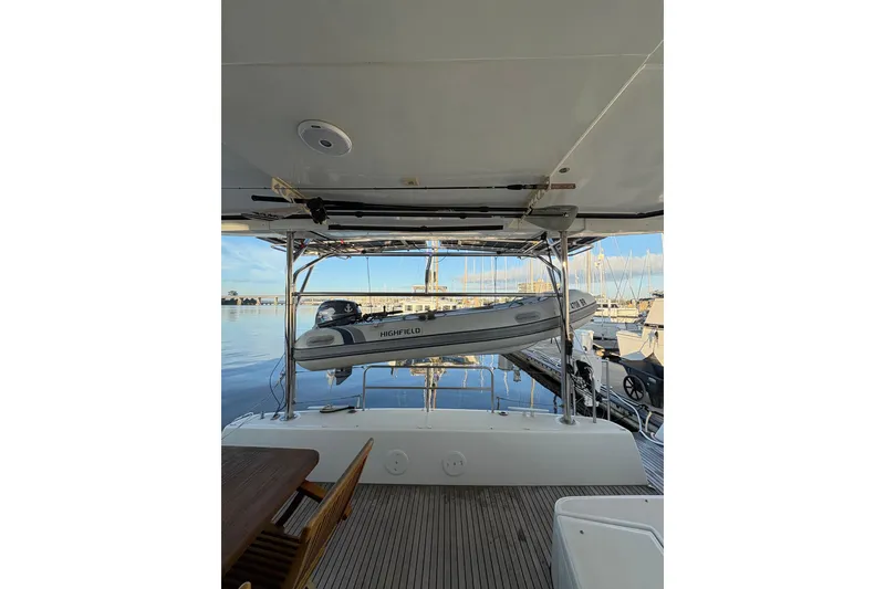 Slide: The Image of 2020 Lagoon 42 yacht with a Highfield dinghy on davits at a marina. - 96