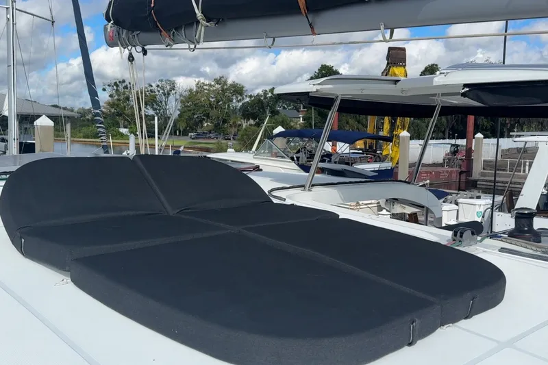 Slide: The Image of 2020 Lagoon 42 catamaran with black deck cushions, docked at a marina. - 19