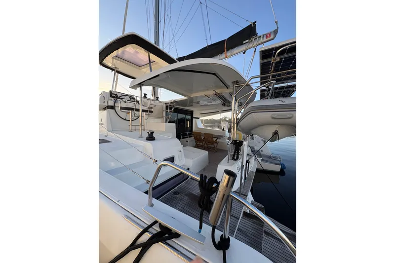 Slide: The Image of 2020 Lagoon 42 catamaran with modern deck and seating area, docked at marina. - 94