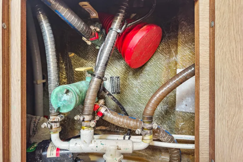 Slide: The Image of Engine compartment of a 2020 Lagoon 42 catamaran with visible hoses and components. - 74