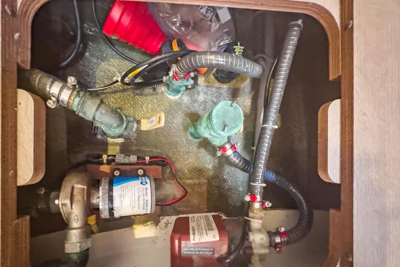 Slide: The Image of Engine compartment of a 2020 Lagoon 42 catamaran with visible hoses and components. - 73