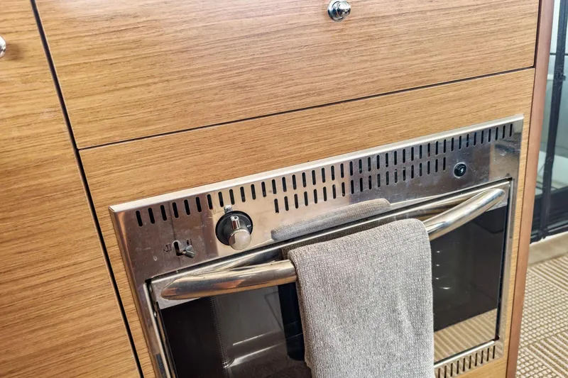 Slide: The Image of Wood-paneled oven in 2020 Lagoon 42 yacht kitchen with towel on handle. - 31