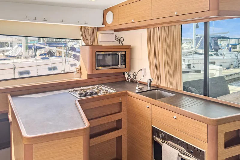 Slide: The Image of Modern kitchen interior of 2020 Lagoon 42 yacht with stove, sink, and microwave. - 25