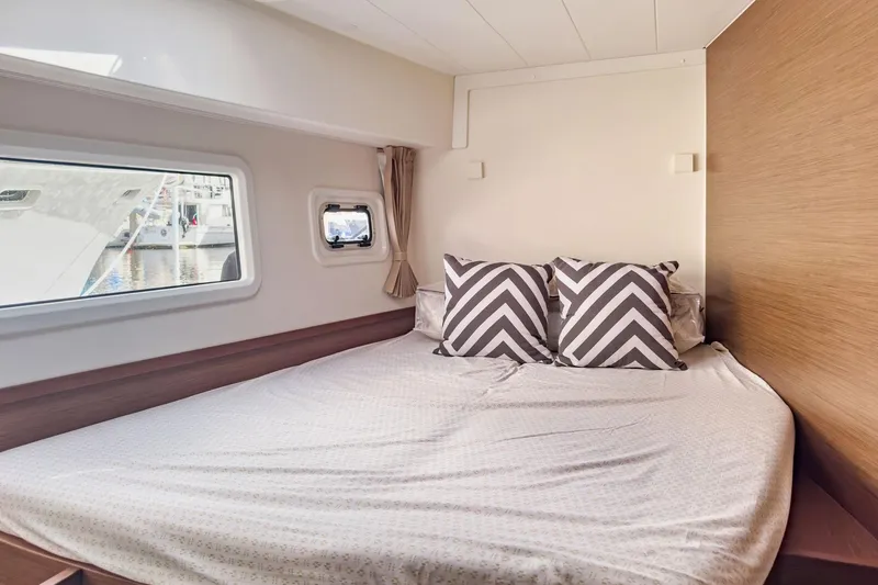 Slide: The Image of Cozy bedroom interior of 2020 Lagoon 42 yacht with chevron pillows and window view. - 58