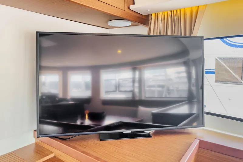 Slide: The Image of Flat-screen TV inside 2020 Lagoon 42 yacht, reflecting interior and exterior views. - 36