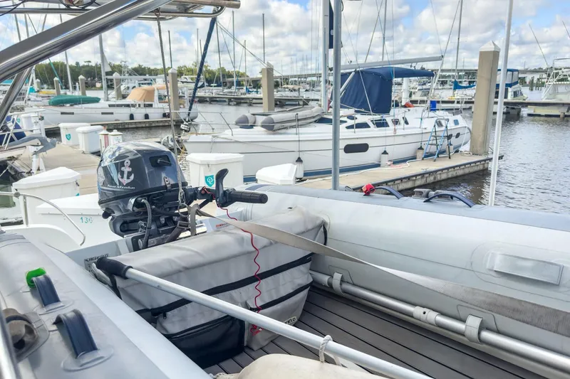 Slide: The Image of Inflatable boat with motor at marina, near Lagoon 42 catamaran, 2020 model. - 90