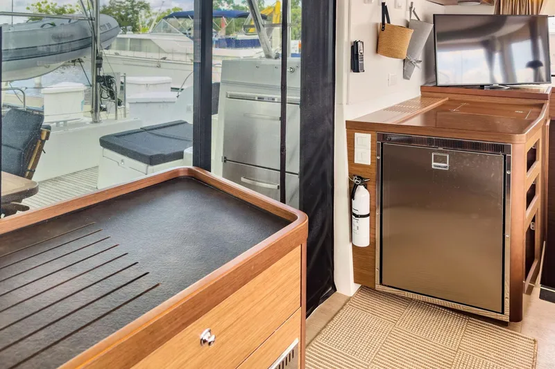 Slide: The Image of Interior of a 2020 Lagoon 42 yacht featuring a modern kitchen and outdoor view. - 23