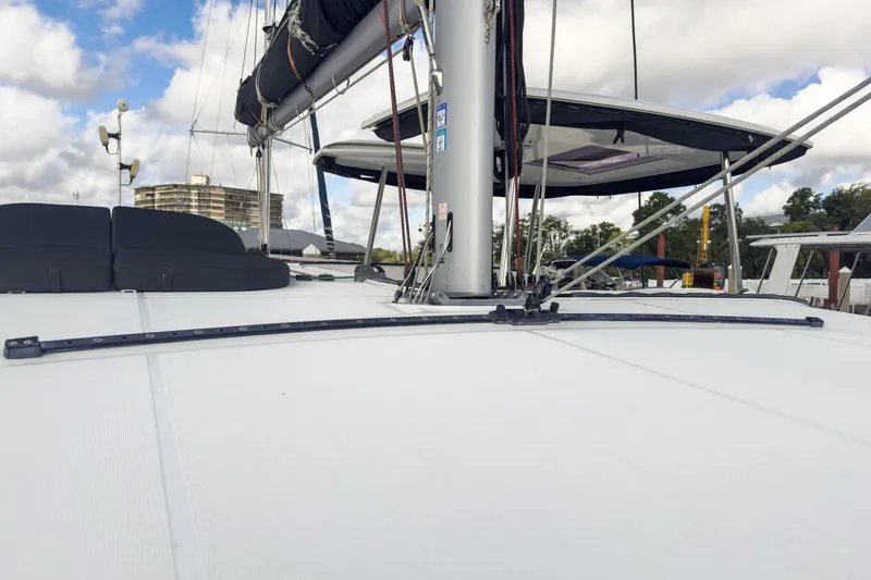 Slide: The Image of 2020 Lagoon 42 catamaran deck with mast and rigging under cloudy sky. - 18