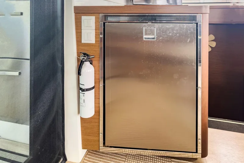 Slide: The Image of Stainless steel fridge and fire extinguisher in 2020 Lagoon 42 yacht interior. - 32