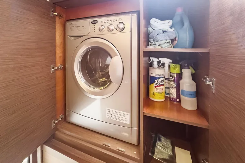 Slide: The Image of Laundry area on Lagoon 42 yacht, featuring a washing machine and cleaning supplies. - 50